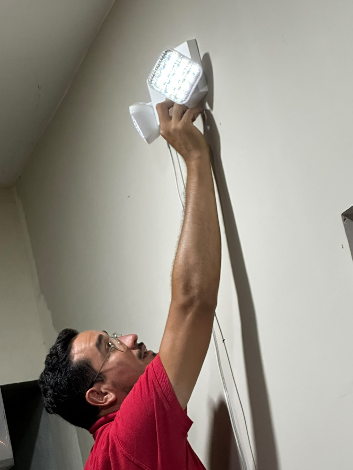 Técnico instalando lámpara de iluminación de emergencia